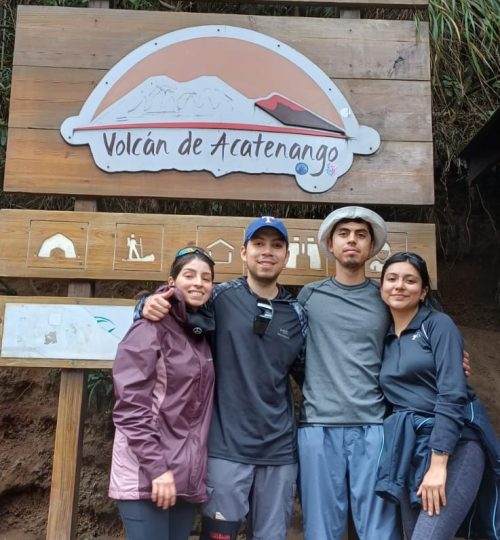 Visitantes junto al letrero de bienvenida del Volcán Acatenango